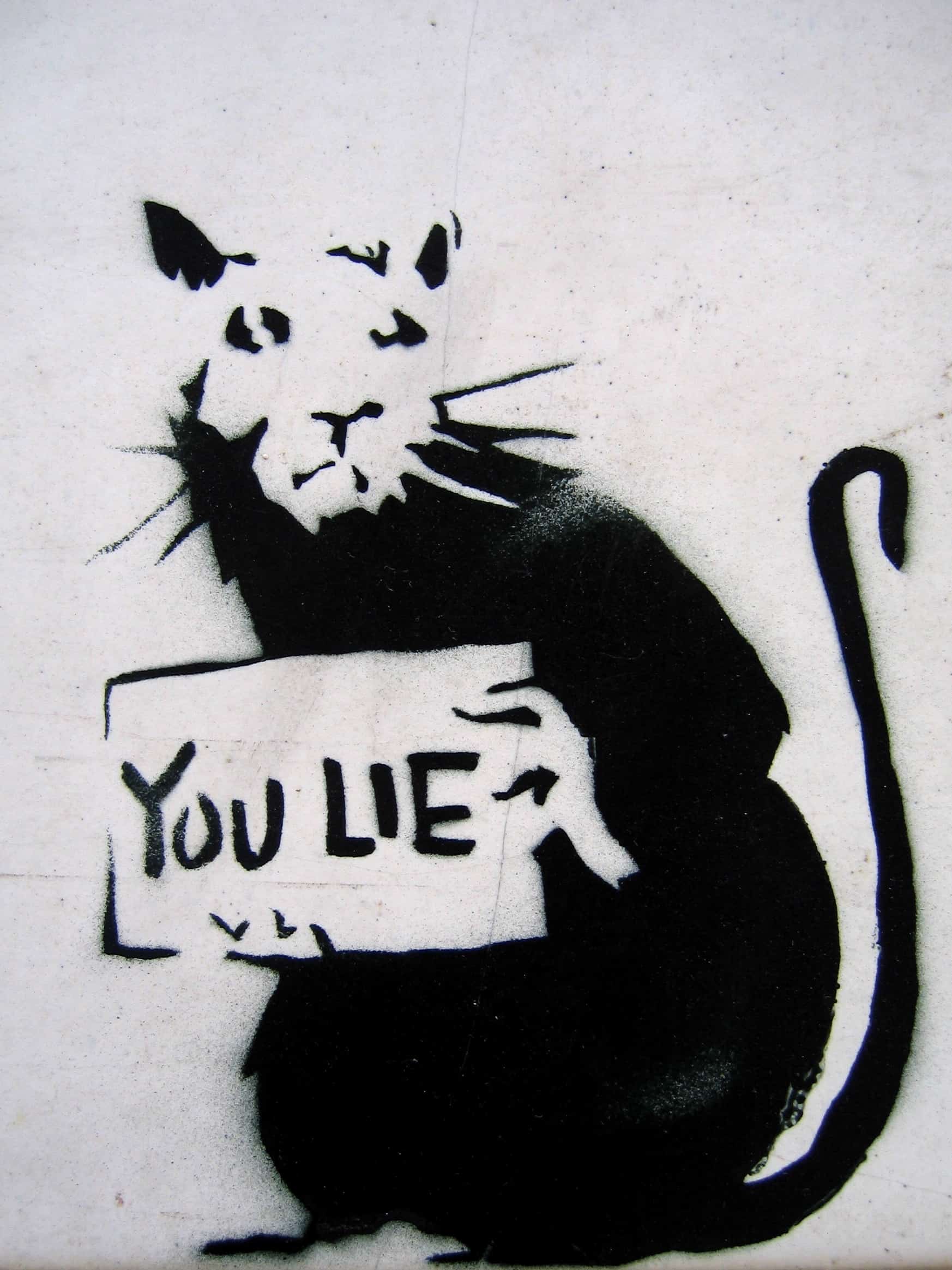 a graffiti of a rat holding a sign written you lie