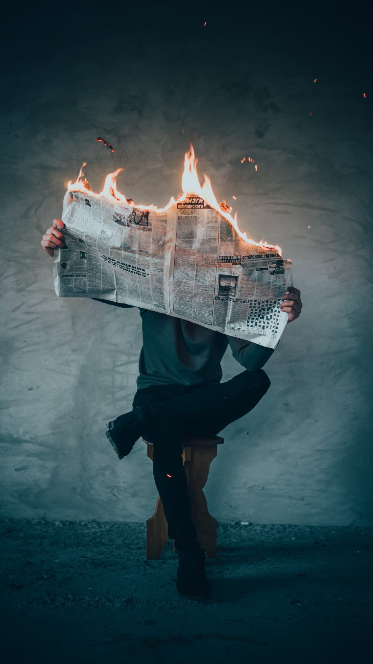 A man sitting reading a journal on fire