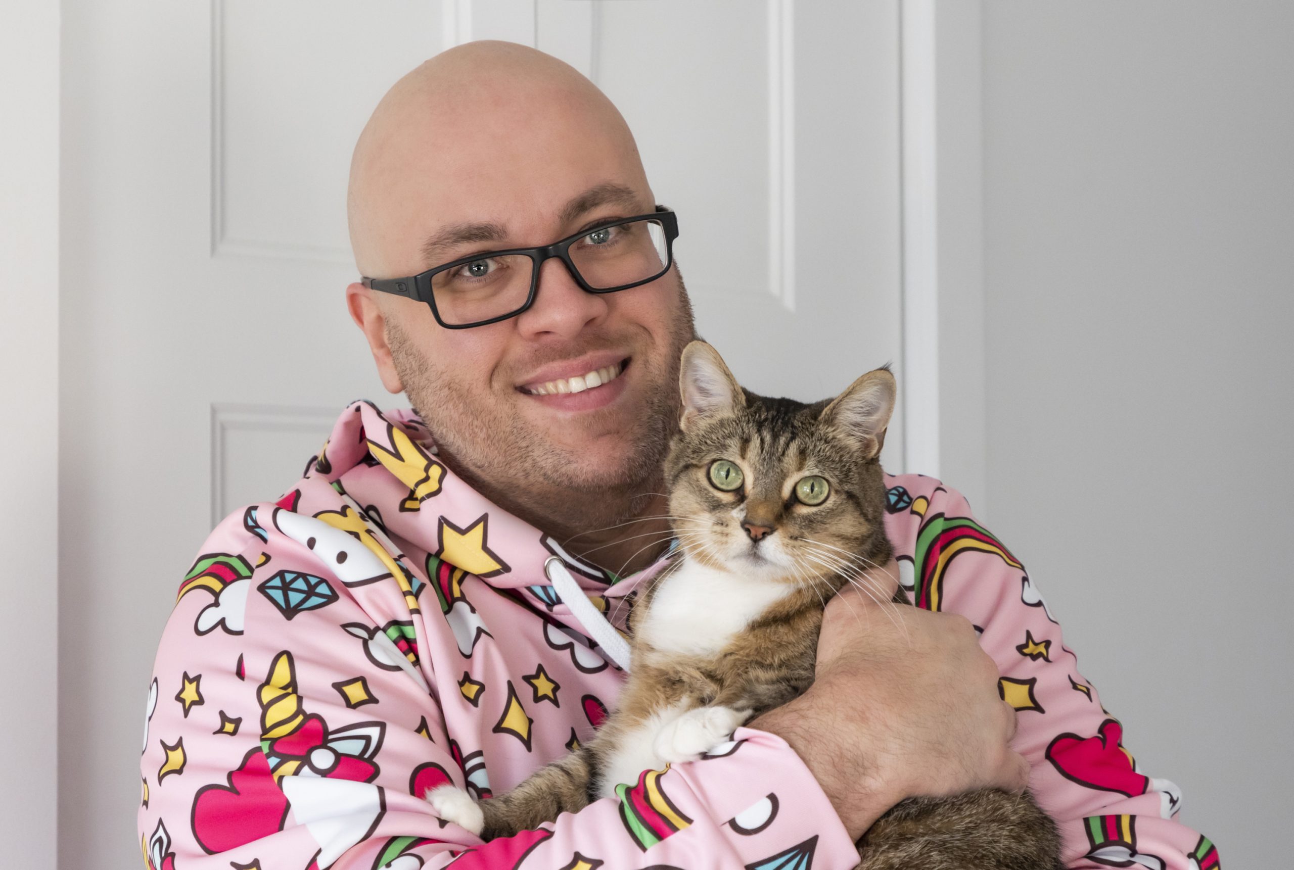 Me smiling holding Nina my cat and wearing my unicorn, stars and heart hoodie