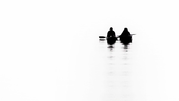 two people canoeing in a white picture